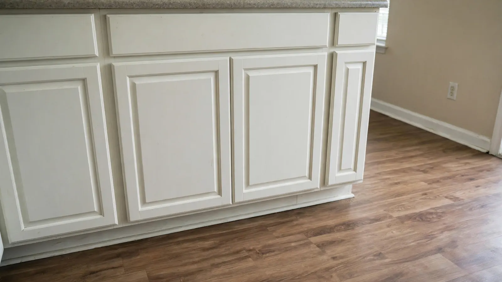 After: The same kitchen with a new sink cabinet base and flat new flooring