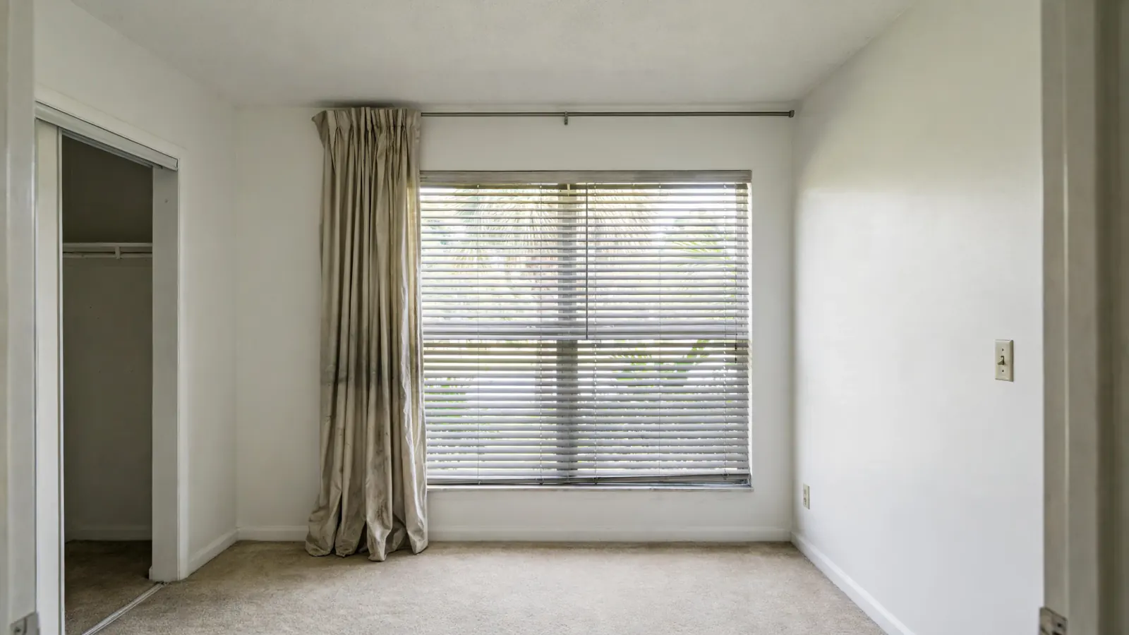 After: The same bedroom with clean white walls and fresh curtains