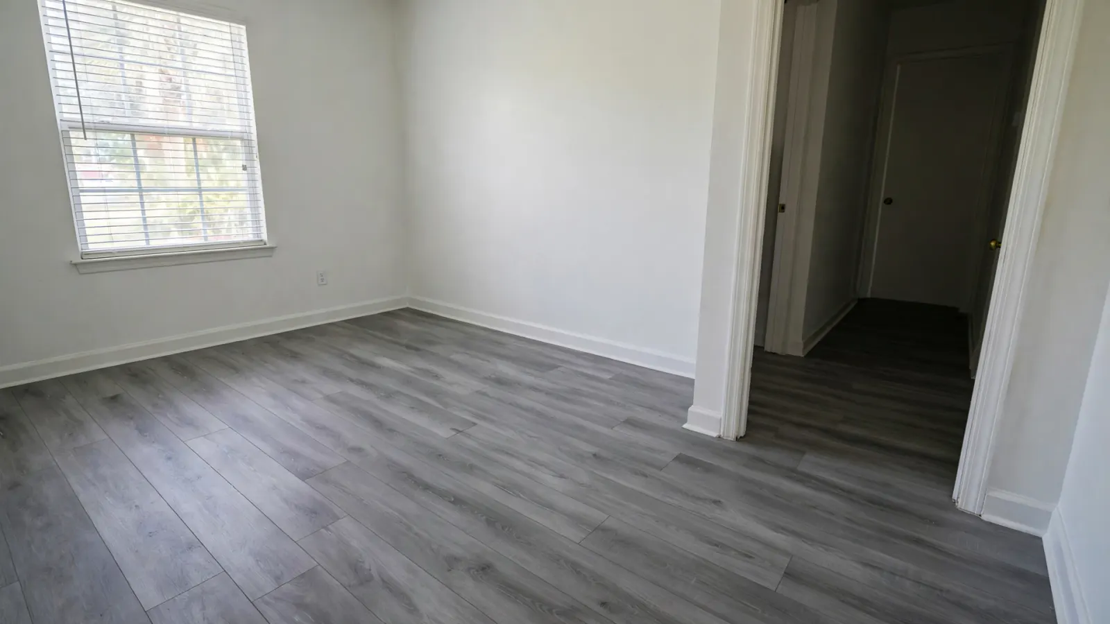 After: The same bedroom with new vinyl plank flooring and clean walls